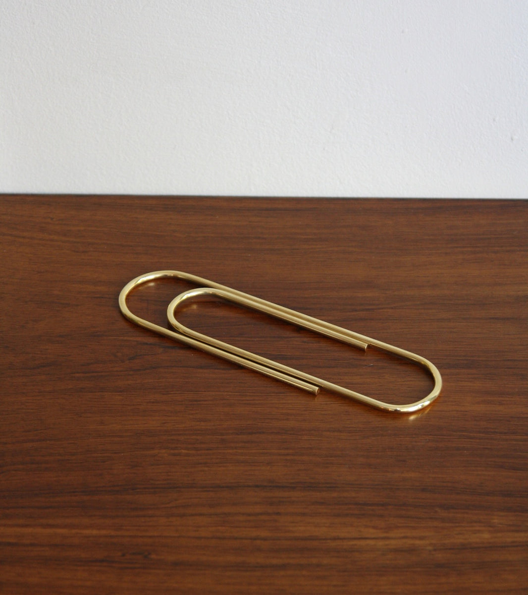 An oversized paper clip designed by Carl Auböck, crafted in brass and available at Sigmar London. This iconic midcentury design piece showcases the playful yet functional style of the Auböck workshop.